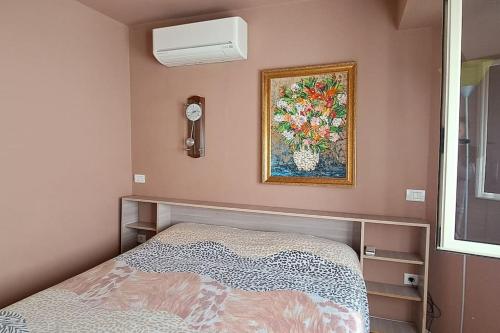 een slaapkamer met een bed en een schilderij aan de muur bij SUNNY House in Tirana