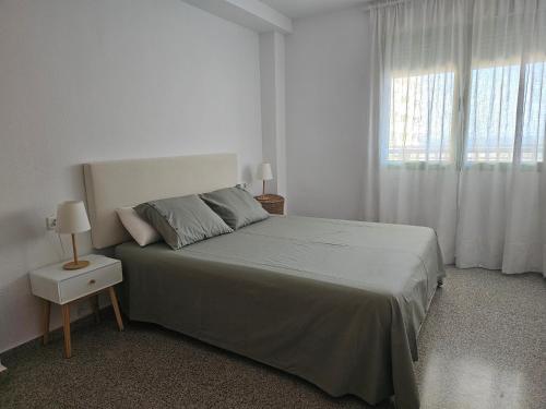 una camera bianca con un letto e una finestra di BEACH VALENCIA 22 Apartment facing the sea with frontal views a Valencia