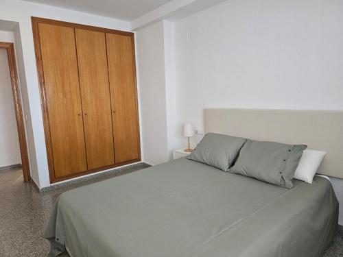 una camera con letto e armadio in legno di BEACH VALENCIA 22 Apartment facing the sea with frontal views a Valencia