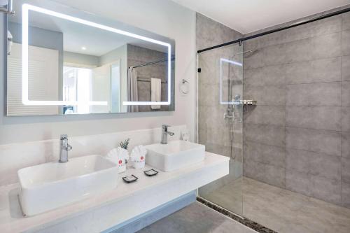 baño con 2 lavabos y ducha de cristal en Ramada by Wyndham St Kitts Resort 