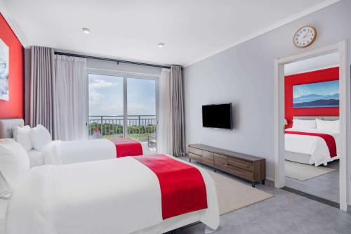 a hotel room with two beds and a television at Ramada by Wyndham St Kitts Resort 