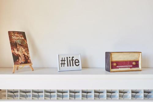 a shelf with two books and a sign on it at Urban Serviced Apartments in Skopje