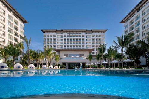 a large swimming pool in front of a hotel at The Mermoon Resort Hainan Tufu Bay, Tapestry By Hilton in Lingshui