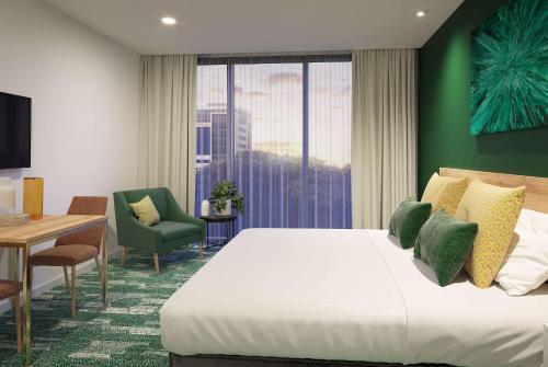 una camera d'albergo con letto, tavolo e finestra di La Quinta by Wyndham Ellerslie Auckland ad Auckland
