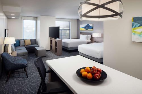 una camera d'albergo con un cesto di frutta su un tavolo di Hyatt House Vacaville a Vacaville