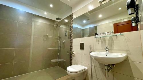 uma casa de banho com um WC, um lavatório e um chuveiro em Riga Unimars Hotel em Riga
