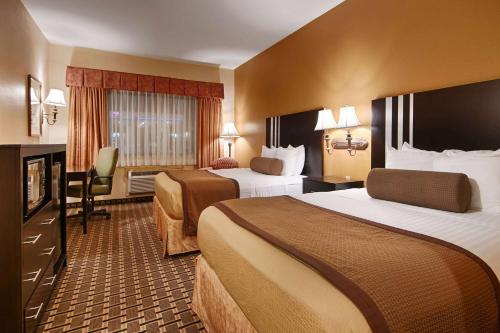 休斯頓的住宿－Days Inn & Suites by Wyndham Sam Houston Tollway，酒店客房设有两张床和电视。