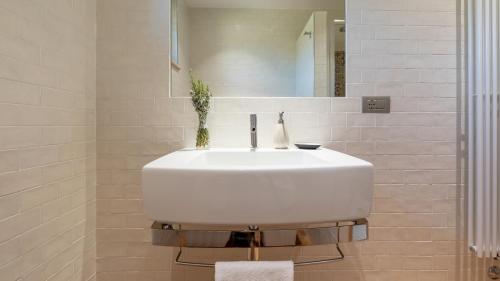 a white sink in a bathroom with a mirror at CASALE GROTTINI 8, Emma Villas in Manciano
