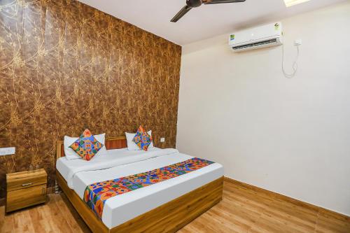 1 dormitorio con cama y pared en FabHotel Moon Gaze Inn, en Kānpur