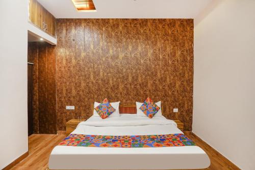 a bedroom with a bed and a wall at FabHotel Moon Gaze Inn in Kānpur