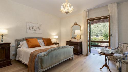 een slaapkamer met een bed, een stoel en een raam bij VILLA ADISA 8, Emma Villas in Uzzano