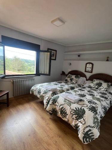 sypialnia z 2 łóżkami i dużym oknem w obiekcie Casa Boni y Florina w mieście Nava