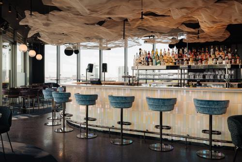 a bar with blue stools in a restaurant at DoubleTree by Hilton Amsterdam Centraal Station in Amsterdam