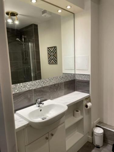 a white bathroom with a sink and a mirror at Attractive Edinburgh Leith Apartment in Edinburgh