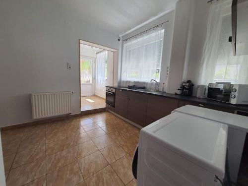 a kitchen with a counter top and a large window at Pikoló Vendéglő és Vendégház in Bakonybél