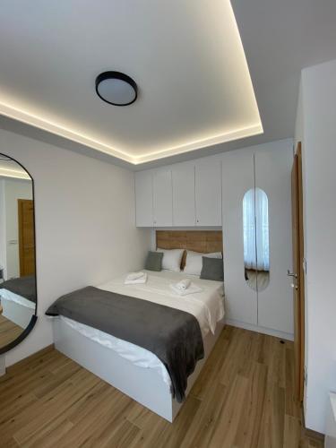a bedroom with a large bed and a mirror at Apartman Jahorina MD in Jahorina