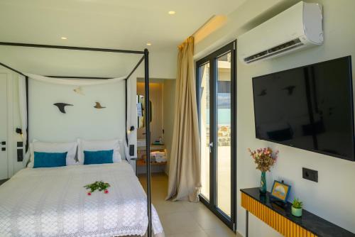 a bedroom with a large bed and a tv at Majestic View Villas in Agios Nikolaos