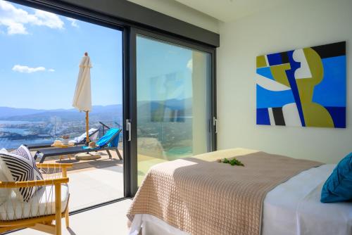 a bedroom with a bed and a large glass window at Majestic View Villas in Agios Nikolaos