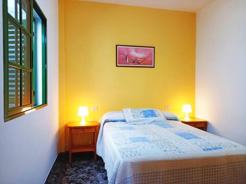 a bedroom with a bed and two lamps on tables at Bonita casa cerca de la playa - Chalet Eras Costeras in Las Eras