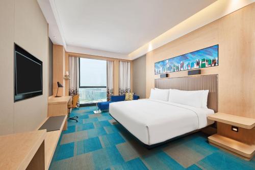 a hotel room with a white bed and a television at Aloft Shanghai Zhangjiang Haike in Shanghai