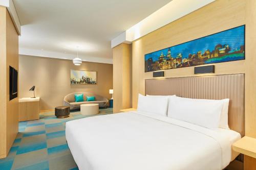 a hotel room with a bed and a couch at Aloft Shanghai Zhangjiang Haike in Shanghai