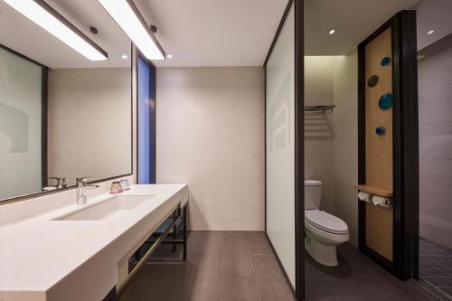 a bathroom with a sink and a toilet at Aloft Shanghai Zhangjiang Haike in Shanghai