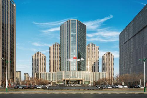 a tall building in a city with tall buildings at JW Marriott Hotel Harbin River North in Harbin