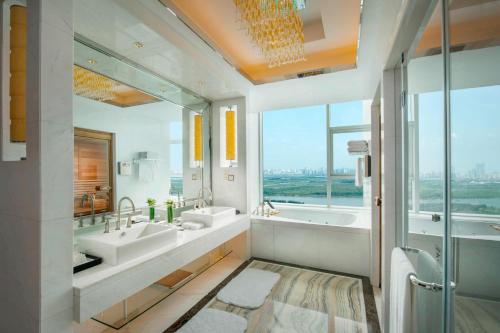 uma casa de banho com 2 lavatórios e uma grande janela em JW Marriott Hotel Harbin River North em Harbin