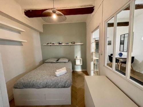 Dormitorio pequeño con cama y mesa en T2 calme centre historique AIX EN PCE en Aix-en-Provence