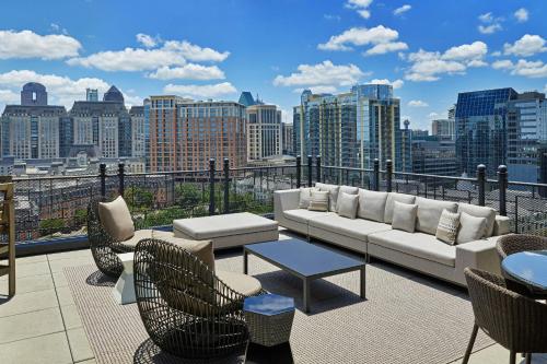 a balcony with a couch and chairs and a city skyline at Le Meridien Dallas, The Stoneleigh in Dallas