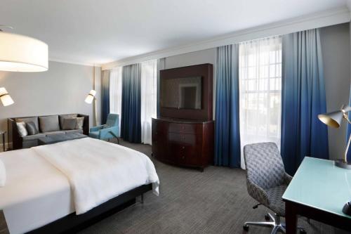 a hotel room with a bed and a television at Le Meridien Dallas, The Stoneleigh in Dallas