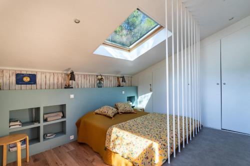um quarto com uma cama e uma clarabóia em Gite l'Instant - Au cœur d'une oliveraie em Belgentier