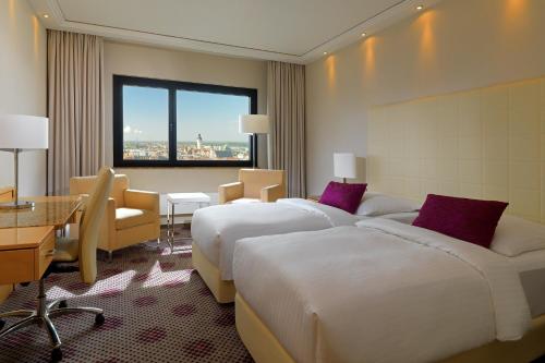 a hotel room with two beds and a window at The Westin Leipzig in Leipzig