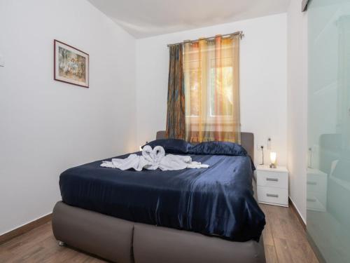 um quarto com uma cama com lençóis azuis e uma janela em Villa St Nikola with jacuzzi and private swimming pool em Ružići