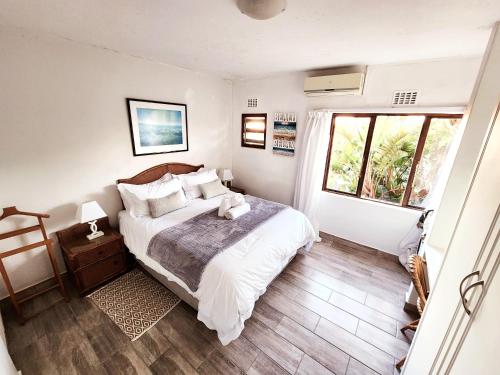 a bedroom with a large bed and a window at San Lameer Villa 2012 in Southbroom