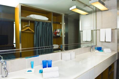 a bathroom with a sink and a large mirror at Aloft Beijing, Haidian in Beijing