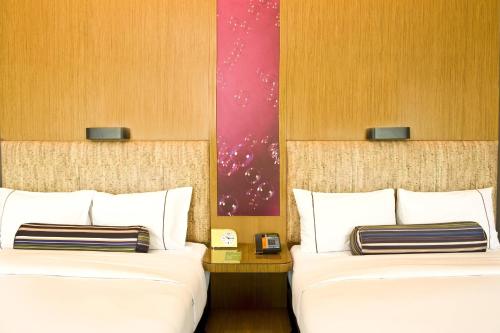 two beds in a hotel room with two beds sidx sidx sidx at Aloft Beijing, Haidian in Beijing