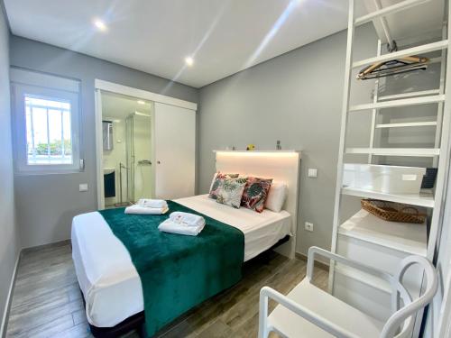 - une petite chambre avec un lit et un miroir dans l'établissement Quarteira Stylish 2 by Homing, à Quarteira