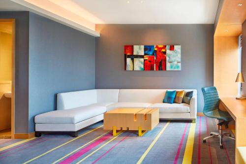 a living room with a white couch and a table at Aloft Dynamic Town in Longgang
