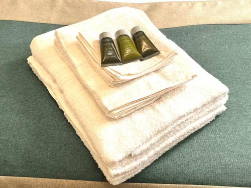 a pile of towels with two bottles on a table at Remarkable 5-Bed House in Horley in Horley