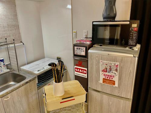 uma cozinha com um micro-ondas em cima de um frigorífico em セカンド-privatespace Second- em Kurume