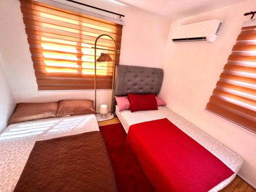a small bedroom with two beds and a window at Two-Bedroom Townhouse Camella Bacolod South in Bacolod