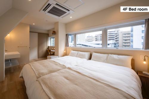 a bedroom with a large bed with a large window at Totonou & GIVE Nakano Sakaue in Tokyo