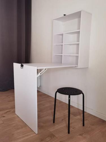 - un bureau blanc avec un tabouret dans l'établissement Maisonnette entière 2 pièces, 30 mn Roissy, 30 mn Disney, à Brégy