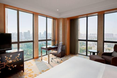 a room with a desk and a room with windows at The Westin Hefei Baohe in Hefei