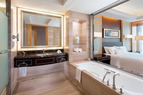 a bathroom with a bed and a tub and a sink at The Westin Hefei Baohe in Hefei
