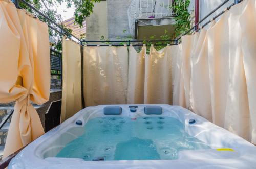 eine Whirlpool-Badewanne im Hof mit Vorhängen in der Unterkunft ROZA in Dramalj