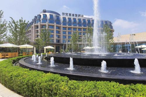 een fontein voor een gebouw met een gebouw bij Sheraton Qinhuangdao Beidaihe Hotel in Qinhuangdao