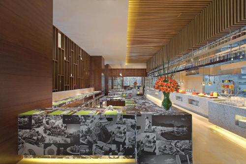 Sheraton Qinhuangdao Beidaihe Hotel في تشنهوانغداو: مطبخ كبير مع إناء من الزهور على منضدة