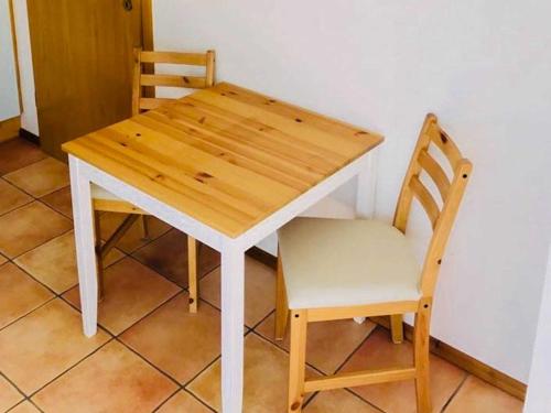 einen Holztisch und einen Stuhl neben einem Tisch und einem Tisch in der Unterkunft Ferienwohnung Herzogstadt in Wolgast
